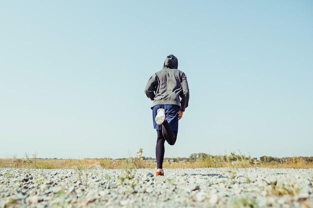 Fare sport. Sprint corridore uomo all'aperto nella natura scenica. Traccia muscolare adatta di addestramento dell'atleta maschio che corre per la maratona.