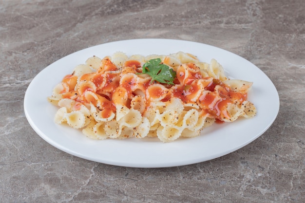 Farfalle alla bolognese alla piastra, sulla superficie di marmo.