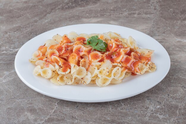 Farfalle alla bolognese alla piastra, sulla superficie di marmo.