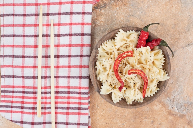 Farfalle con peperoncino e spezie in ciotola di legno.