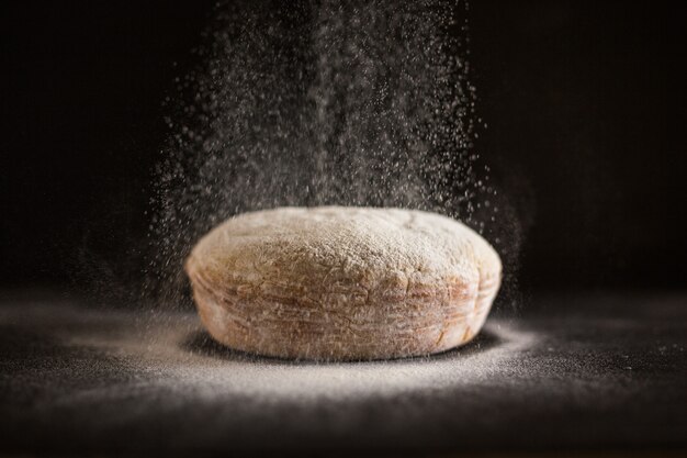 Farina che viene spruzzata sul pane appena sfornato