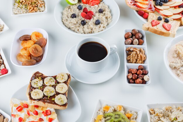 Farina d'avena con frutta, noci, caffè, sandwich di frutta, albicocche secche in piatti