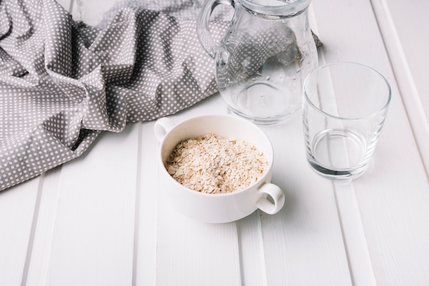 Farina d&#39;avena cruda nella ciotola sul tavolo