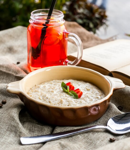 Farina d'avena di vista laterale con fragole e una bibita