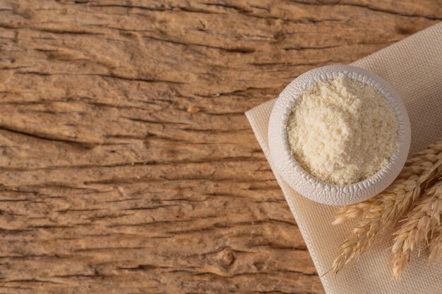 Farina d&#39;avena e farina d&#39;avena in una tazza su un tavolo su un pavimento di legno