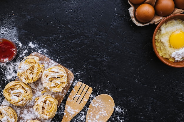 Farina e uova vicino a pasta e strumenti