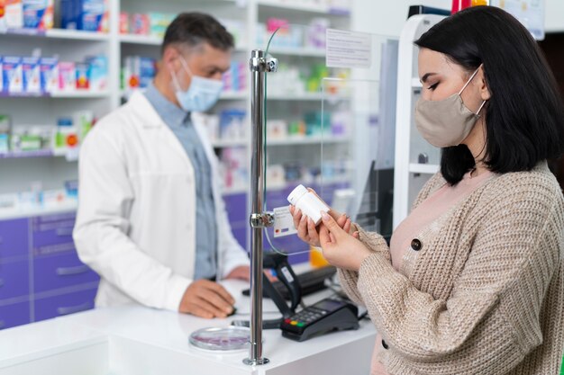 Farmacista di tiro medio che aiuta il paziente