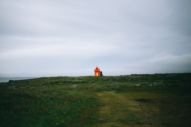 Faro in riva al mare dell'Islanda, ora legale, giornata di sole