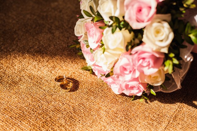 fedi nuziali con bouquet di rose rosa