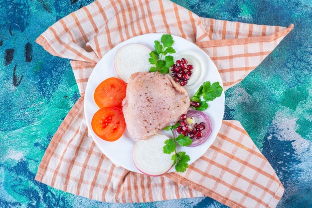 Fegato di pollo, foglie di lattuga e coscia di pollo su un piatto sul canovaccio