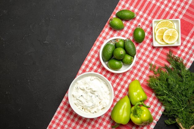 Feijoa fresco vista dall'alto con crema di limone e peperone verde su superficie scura colore del prodotto farina di frutta