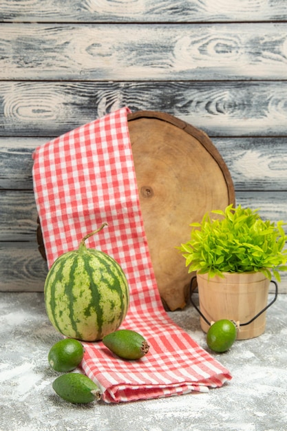 Feijoa verde fresco di vista frontale con l'anguria su colore verde dolce della frutta del fondo grigio