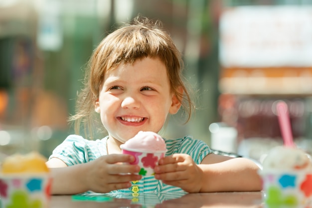 Felice 3 anni di ragazza a mangiare gelato