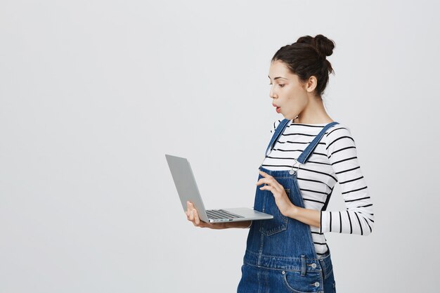 Felice carino femmina libero professionista utilizzando laptop