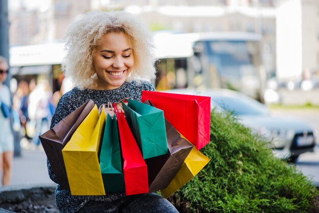 Felice cliente femminile con sacchetti di carta