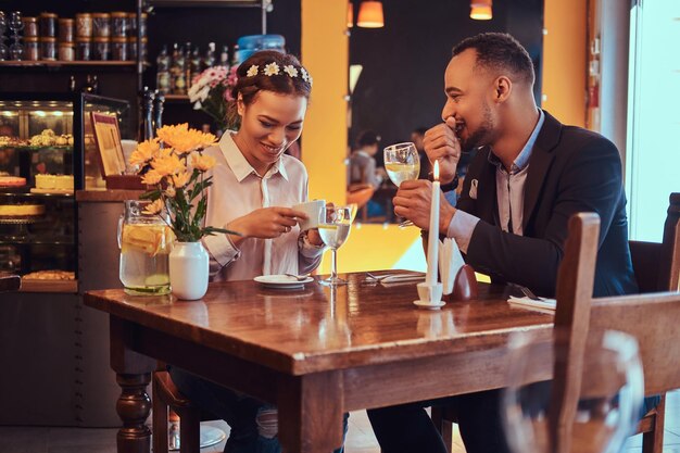 Felice coppia afro-americana attraente innamorata che si diverte insieme in un ristorante al loro appuntamento, una bella coppia che si diverte a vicenda.