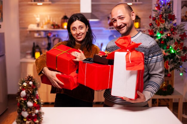 Felice coppia sposata che tiene un regalo regalo segreto con un nastro su di esso