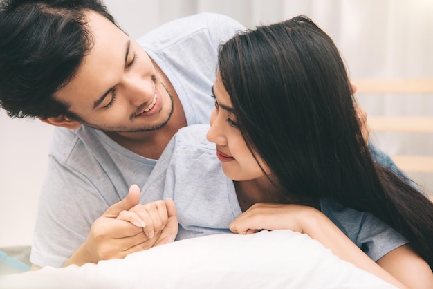 Felice dolce giovane coppia sul letto in camera da letto momenti romantici