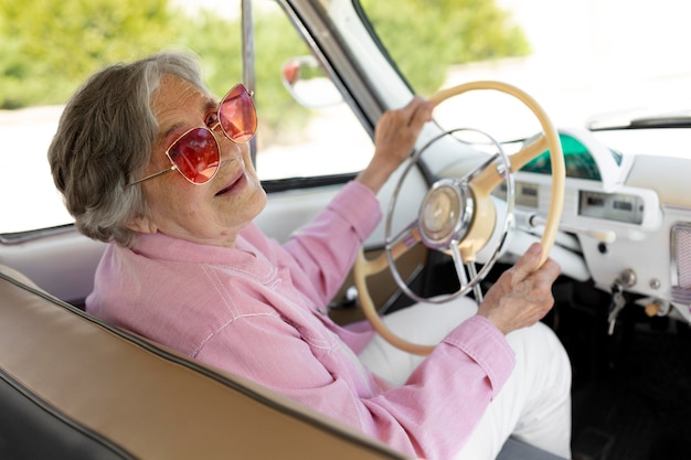 Felice donna anziana che viaggia da sola in auto