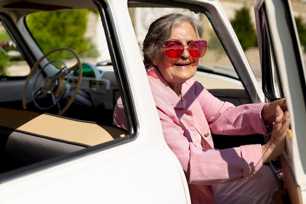 Felice donna anziana che viaggia da sola in auto