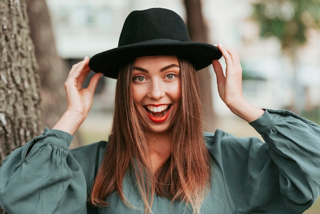 Felice donna che indossa un cappello nero