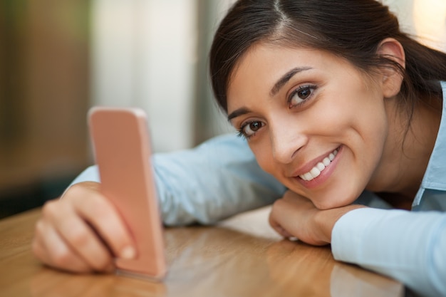 Felice donna che si trova sul contatore con Smartphone