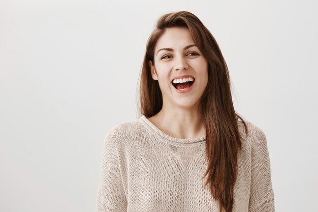 Felice donna spensierata ridendo e sorridendo alla telecamera