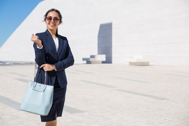 Felice elegante donna d&#39;affari si dirigono al suo ufficio