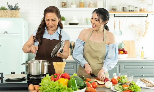 Felice famiglia asiatica che prepara cibo in cucina a casa Goditi l'attività familiare insieme