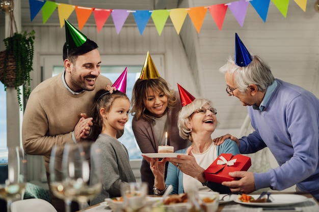 Felice famiglia di più generazioni sorprendente donna senior con una festa per il suo compleanno