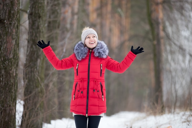 Felice femmina sorridente in giacca invernale rossa, all&#39;aperto