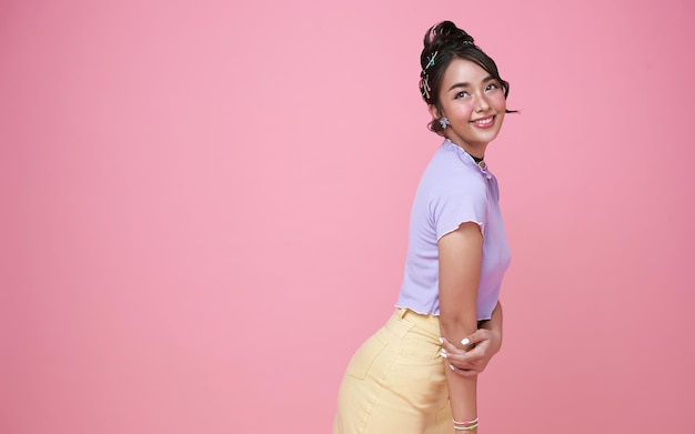 Felice giovane adolescente asiatica isolata su sfondo rosa