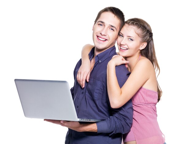 Felice giovane coppia con laptop su sfondo bianco