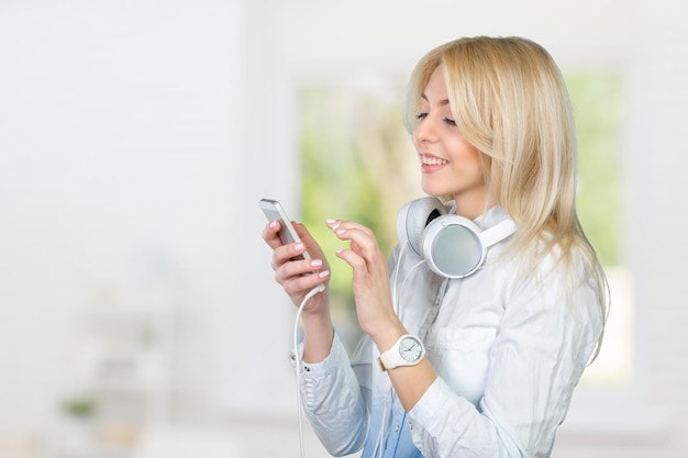 Felice giovane donna bionda che ascolta la musica