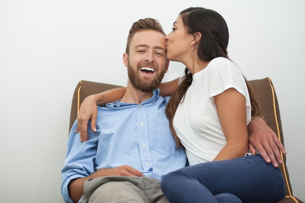 Felice giovane donna che bacia il suo uomo con passione