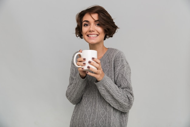 Felice giovane donna che beve il tè.