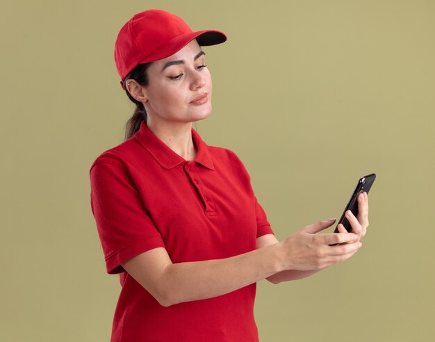 Felice giovane donna delle consegne in uniforme e berretto