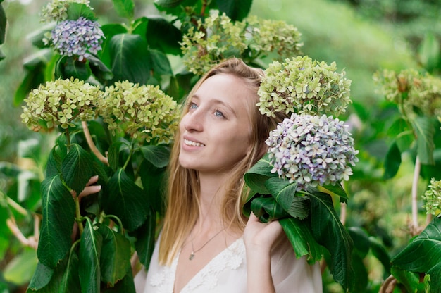 Felice giovane donna in posa con i fiori