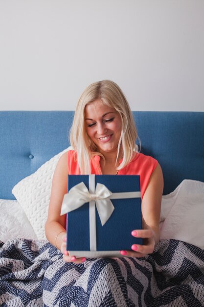 Felice giovane donna in possesso di un regalo