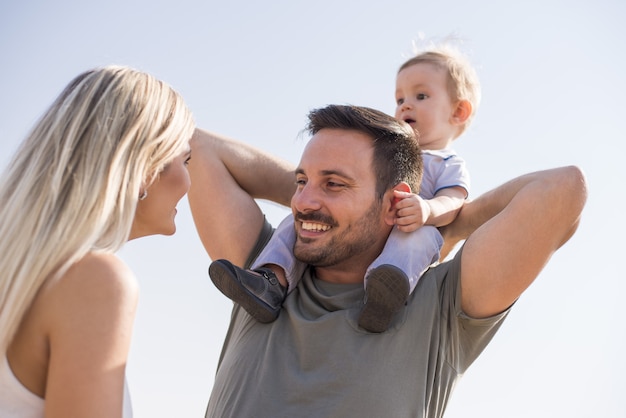 Felice giovane famiglia godendo la giornata in una bella giornata di sole