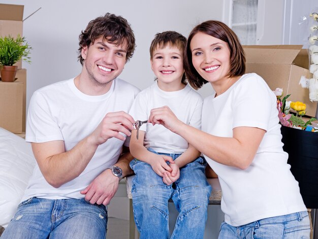 Felice giovane famiglia seduta nel loro nuovo appartamento