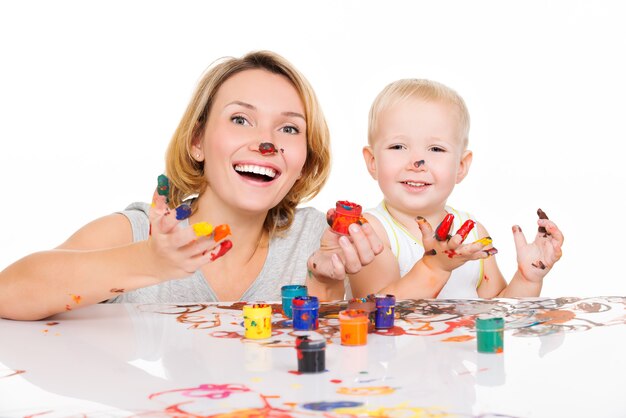 Felice giovane madre e bambino con le mani dipinte isolate su bianco.