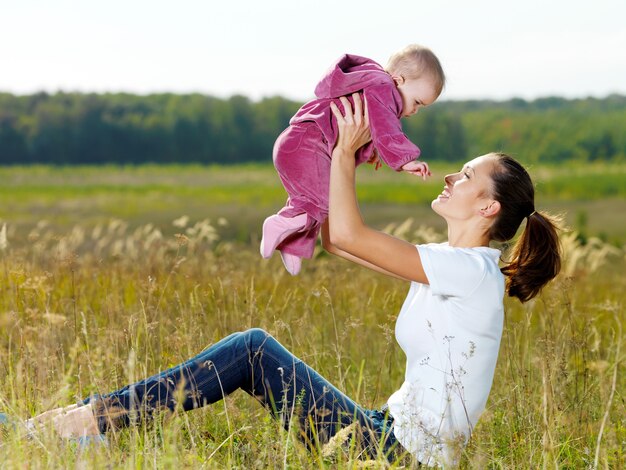 Felice giovane mather gioca con il bambino sorridente