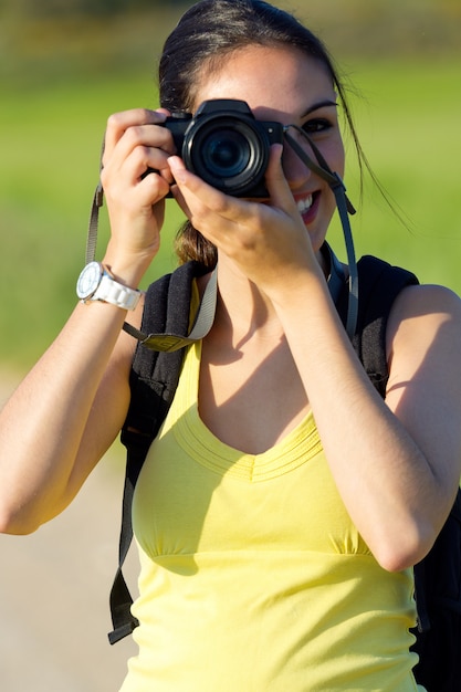 Felice giovane ragazza che scatta foto sul campo