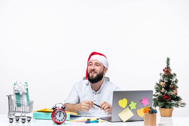 Felice giovane uomo d'affari positivo con cappello di babbo natale che lavora da solo