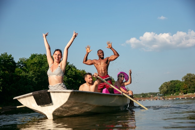 Felice gruppo di amici divertendosi mentre ridevano e nuotavano nel fiume