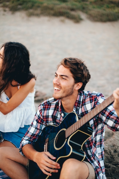 Felice l&#39;uomo suonare la chitarra in spiaggia