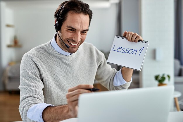 Felice lavoratore freelance che tiene una lezione di formazione sul computer portatile da casa