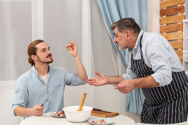 Felice padre e figlio che servono la cena