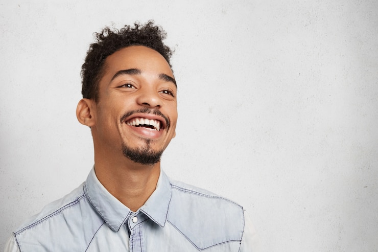 Foto gratuito felice, positivo, giovane uomo di razza mista con baffi e barba, sorride felice